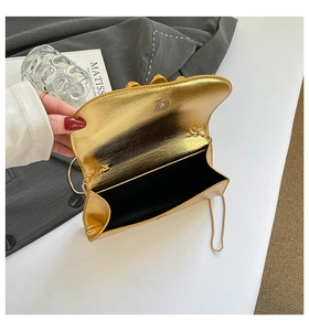 Détail du sac bandoulière miroir doré montrant le fermoir magnétique et la doublure