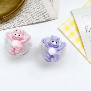 Detail of cute pastel bear phone grip holders with heart paw motifs on a flat surface
