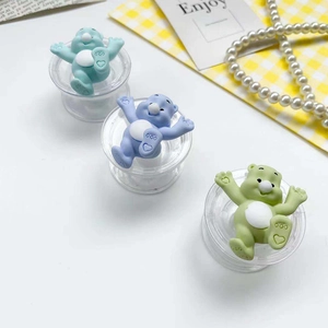 Close-up of cute cartoon bear phone socket holders in pastel green, purple and lime colors
