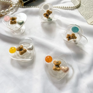 Detailed close-up of heart-shaped phone grips with cute resin bears and colorful beads