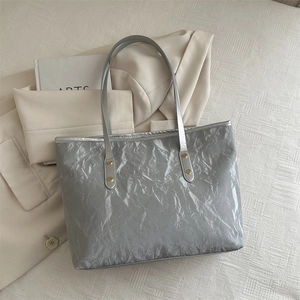 Metallic silver tote bag with crinkled texture, slim straps and golden rivets detail