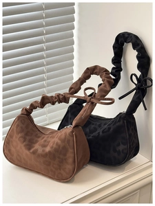 Détail de sacs à imprimé léopard avec bretelles plissées et nœuds décoratifs