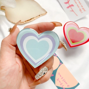 Close-up of heart-shaped acrylic phone grip with a colorful layered drip glue design