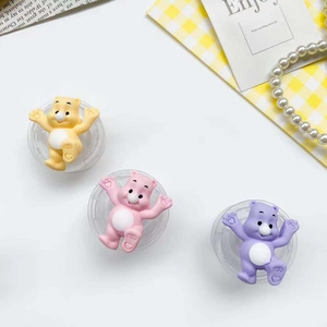 Detail of yellow, pink, and purple cartoon bear phone grips with heart patterns