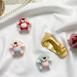 Detailopname van schattige 3D-beervormige pop-sockets in roze en blauw op witte zijde