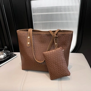 Dark brown woven textured tote bag set with matching small zipper pouch on a leather surface