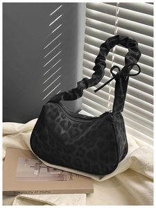 Détail du sac léopard noir avec bandoulière plissée et décoration de nœud