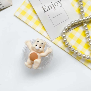 Cute bear phone grip with transparent base shown on a warm aesthetic background