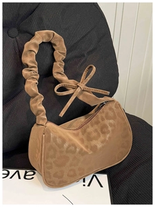 Détail du sac léopard avec poignée froncée, nœud décoratif et fermeture à glissière