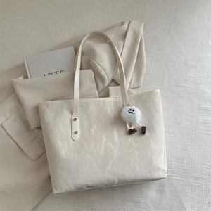 Creamy white marble-textured tote bag with cute plush pendant for daily commute