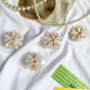 Detailed close-up of daisy-shaped flower phone stands with marble texture and rhinestones