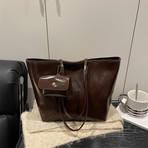 Dark brown high-shine leather tote bag with a small matching pouch and shoulder straps