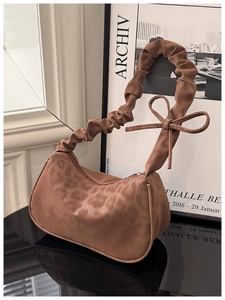 Détail d'un sac à bandoulière léopard avec bandoulière froncée et nœud élégant