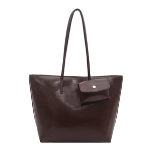 Vintage brown leather tote bag with long shoulder straps and a matching mini pouch charm
