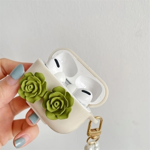 Detail view of cream AirPods Pro case with green roses and artificial pearl strap