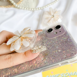 Close-up of sparkling glitter phone case with a white 3D floral pop-up socket stand