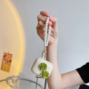 Green camellia floral AirPods case with pearl wrist strap and creamy matte finish
