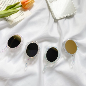 Close-up of four portable fan-shaped makeup mirrors with transparent glitter resin frames