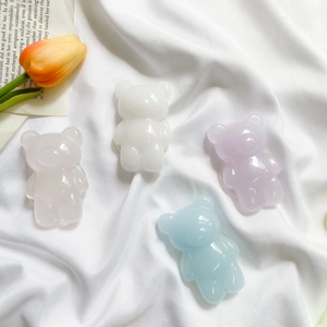 Close-up of cute 3D resin bear phone grips in pastel colors on white silk background