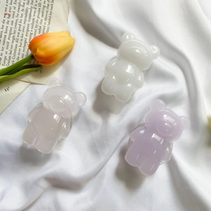 Detailed view of 3D colorful resin bear phone grips on aesthetic white fabric background
