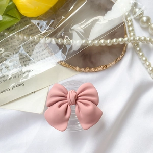 Pink bow grip tok phone holder with a matte finish on white silk background