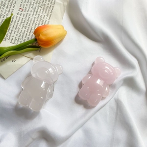 Cute resin teddy bear phone grips in pink and clear white on a retro aesthetic background