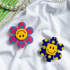 Macro shot of colorful acrylic flower phone grips with polka dots and smiley face centers