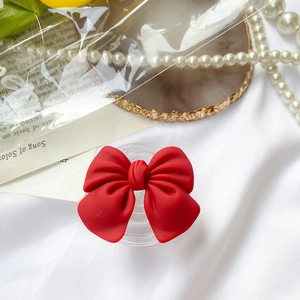 Red matte bow phone grip with foldable airbag base for mobile and tablet support
