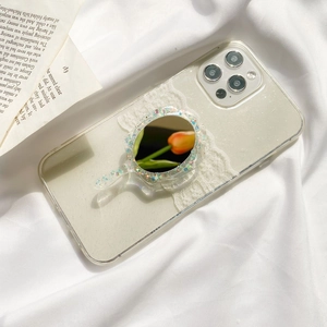 Close-up of clear phone case with a glittery mirror phone stand and lace decoration