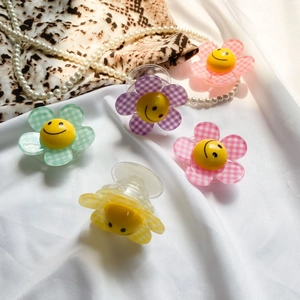 Detail of colorful smiley flower folding phone grips on silk fabric with pearls