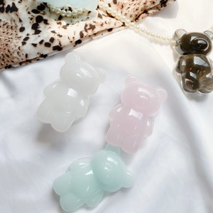 Detail shot of four colorful 3D resin bear phone grips on an elegant silk background
