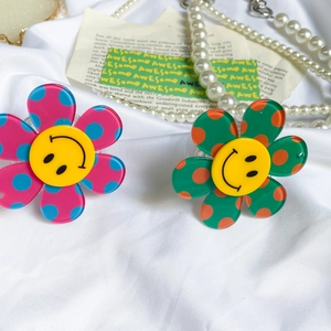 Detail of floral pop socket grip with colorful polka dots and a yellow smiley face