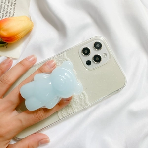 Detail of light blue bear phone grip on a glitter case with floral background