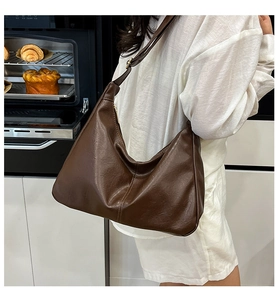 Vue latérale d'un sac hobo vintage marron avec texture cuir grainé et boucle en métal