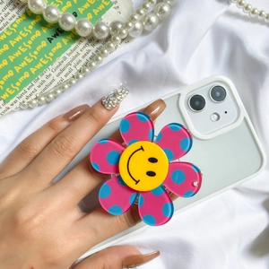 Macro shot of colorful polka dot flower phone grip with yellow smiley face center