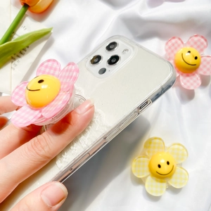 Detail of glitter phone case with cute yellow and pink floral smiley face grip stand