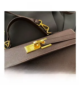 Close-up of brown cross-grain leather texture with gold rectangular twist lock buckle