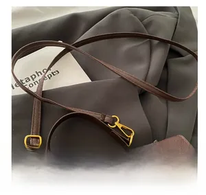 Detail of high-quality brown lychee leather texture and gold metal buckle on handbag