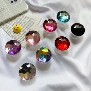 Close-up of colorful gemstone-style expanding phone grips on white silk background