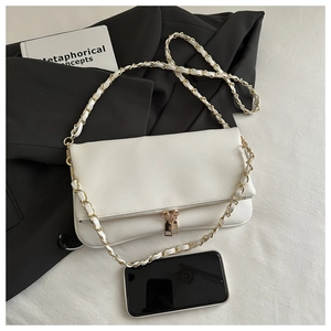 Close-up of white lychee textured bag with gold double-zipper and woven chain strap