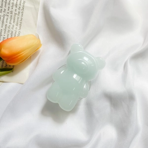 Detail of a cute mint green bear phone socket on white satin with a yellow tulip accent