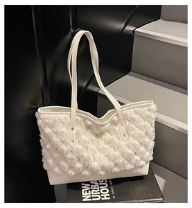 Detail of white plush textured tote bag with smooth leather base and slim double straps