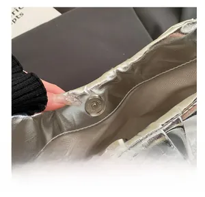 Vista macro della borsa metallica con chiusura magnetica e fodera in tessuto a spina