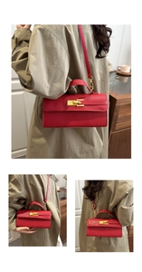 Detail view of red textured leather handbag featuring iconic golden twist-lock closure