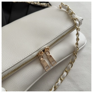 Close-up of white lychee texture leather shoulder bag with golden double zipper details