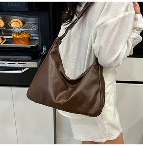 Détail du sac hobo vintage en similicuir marron foncé avec bandoulière large et ajustable