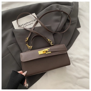 Detailed close-up of dark brown leather texture and golden twist lock on a shoulder bag