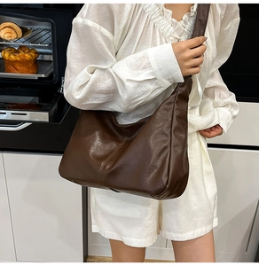 Grand sac porté épaule marron en forme de demi-lune avec texture en cuir mat sur modèle