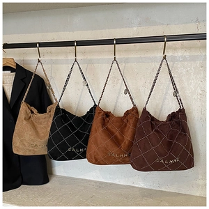 Quilted bucket bags in beige, black, and brown with metallic chains on display