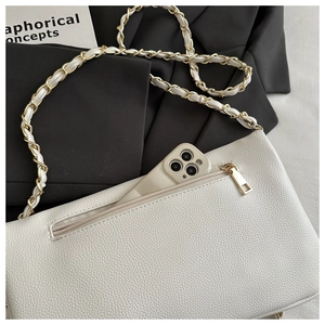 Detail of white lychee leather texture and back zipper pocket with metal chain strap